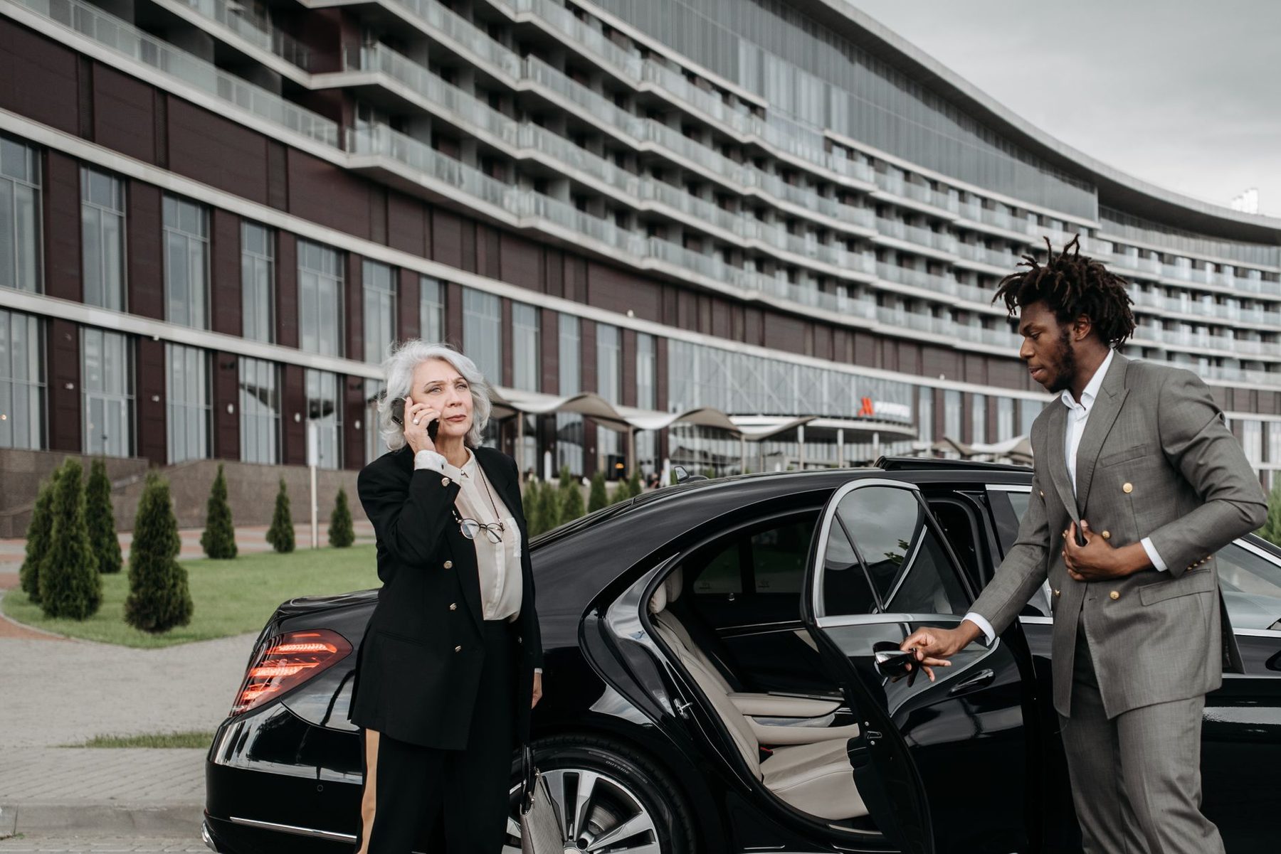 Chauffeur holding a car door open for an executive